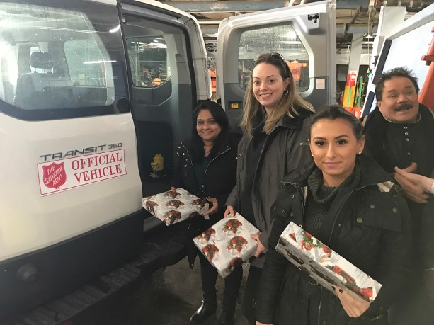 Employees Alice Joseph, Patricia Reilly and Valentina Faraci hand off presents to the Salvation Army from Transervice Long Island’s corporate headquarters in Lake Success. (Photo courtesy of Transervice Logistics)