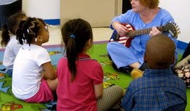 Marilyn Hoffman, well known for her songs and guitar, teaches a group of young students through song. (Photo courtesy of Barbara Masry)