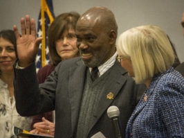 Leonard "Sparrow" Llewellyn, who runs Ernie's Barbershop, waves to people as he comes on stage to accept his proclamation from the Town of North Hempstead. (Photo by Janelle Clausen)