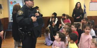 Silverstein Hebrew Academy students listen as police officers from the Great Neck Estates Police Department explain the lifesaving nature of Kevlar vests, and some of the dangers police officers face on a daily basis. (Photo courtesy of Zimmerman/Edelson)