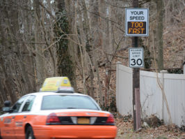 A taxi speeds past a speed radar sign posted on Roslyn Road. (Photo by Janelle Clausen)
