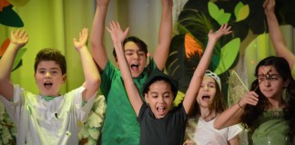 Peter Pan, portrayed by Rafaella Sarraf, leads the Lost Boys and others in cheers. (Photo by Janelle Clausen)