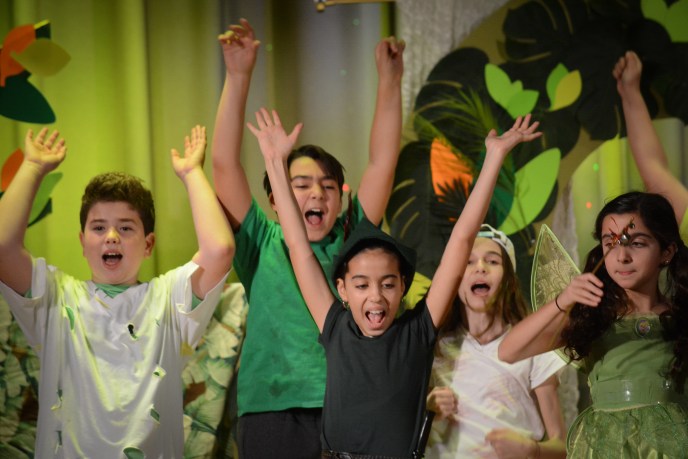 Peter Pan, portrayed by Rafaella Sarraf, leads the Lost Boys and others in cheers. (Photo by Janelle Clausen)