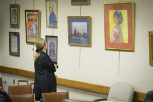 A woman examines a series of works by Suzanne Posner, which will be on display until the end of May. (Photo by Janelle Clausen)