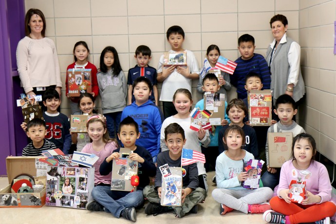 Ms. Ellen Siegel joins Ms. Jillian Brock and her third-grade students with their suitcases. (Photo courtesy of the Great Neck Public Schools)