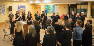 Deborah Tartell, who previously worked as a choral teacher for more than three decades, leads dozens of people through rehearsal. (Photo by Janelle Clausen)