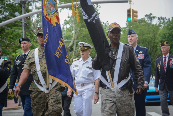Local veterans and service members march down Middle Neck Road. (Photo by Janelle Clausen)