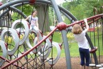 Two friends climb onto a fixture at the park at Village Green. (Photo by Janelle Clausen)