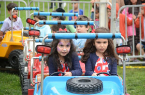 A group of children drive around a track. (Photo by Janelle Clausen)