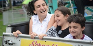 Dana, Sabrina and Kevin Levian, the grandchildren of Norman Namdar, enjoy a ride on the Scrambler at Village Green. (Photo by Janelle Clausen)