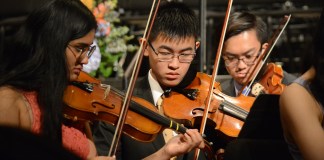 A trio of students in the Great Neck North Symphony Orchestra practice before commencement begins. (Photo by Janelle Clausen)