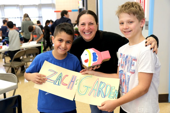 Robin Portnoy is greeted by Saddle Rock students during an activity for the garden renovation project. (Photo courtesy of the Great Neck Public Schools)