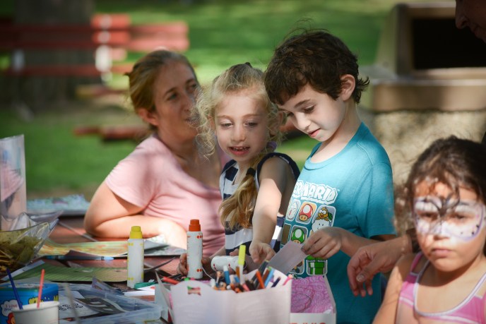 A pair of children work on crafting a message for migrant children. (Photo by Janelle Clausen)