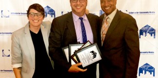 Robert Zahn, educational TV and broadcast media director for the Great Neck Public Schools, is congratulated by Erica Jones and Ulysses E. Campbell, hosts of the 2018 Hometown Media Awards. Mr. Zahn accepted four awards on behalf of GNPS/TV. (Photo courtesy of the Great Neck Public Schools)