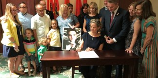 Nassau County Executive Laura Curran signs a pair of substance abuse bills into law as Legislator Joshua Lafazan and others look on. (Photo courtesy of Nassau County Executive Laura Curran's office)