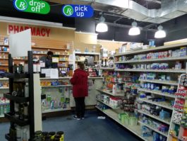 A pharmacist serves a customer on Monday, the last day the pharmacy was open. (Photo by Janelle Clausen)