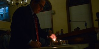 Rabbi Daniel Schweber of Temple Israel lights candles to honor the 11 people killed in the Tree of Life Congregation shooting. (Photo by Janelle Clausen)