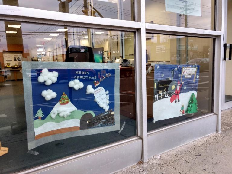 Handmade posters line Plandome Road in anticipation of annual tree lighting