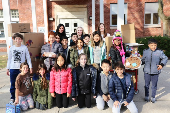 Saddle Rock Principal Luciana Bradley joins student government advisors Jessica Schatz Brennan and Lauren Rio as they help student representatives prepare donations for delivery to the food pantry. (Photo courtesy of the Great Neck Public Schools)