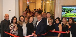 Great Neck Plaza Mayor Jean Celender, sales manager Samuel Marcus, and other guests prepare to cut the ribbon on the new Daniel Gale office. (Photo courtesy of Abby Sheeline of Daniel Gale Sotheby's International Realty)