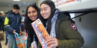 Friends and families enjoyed spending a morning on helping people in need on Sunday, working together to assemble 1,200 Thanksgiving meals for families in need. (Photo by Grace Tan)