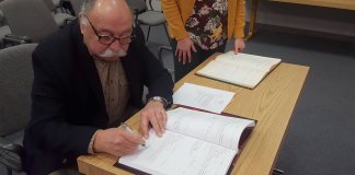 Jacob N. Schwartz signs his oath of office becoming the new associate village justice for the Village of North Hills. (Photo by Teri West)