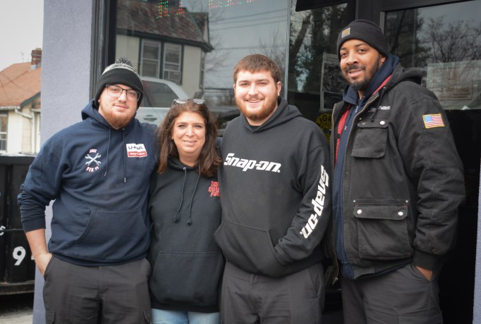 Donna Plakstis and her sons Tyler and Ryan, pictured here with employee William Robertson, will be running the family business Doray Enterprises in Great Neck for as long as it lasts. (Photo by Janelle Clausen)