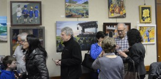 Artists, family and friends examine the work on display in Great Neck Plaza Village Hall. (Photo by Janelle Clausen)