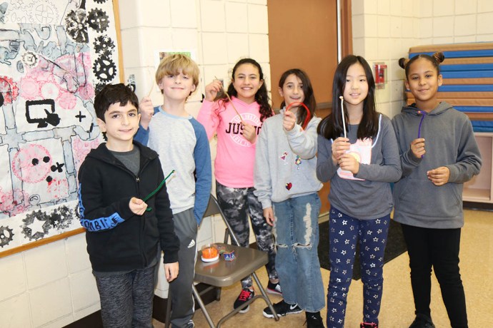 During a presentation by the DEC about the water cycle and the importance of water conservation, Saddle Rock fifth graders participate in an activity where they collect beads from different stations, demonstrating the journey of a water molecule from glaciers and bodies of water into clouds, rain, and groundwater, plants, and humans. (Photo courtesy of the Great Neck Public Schools)