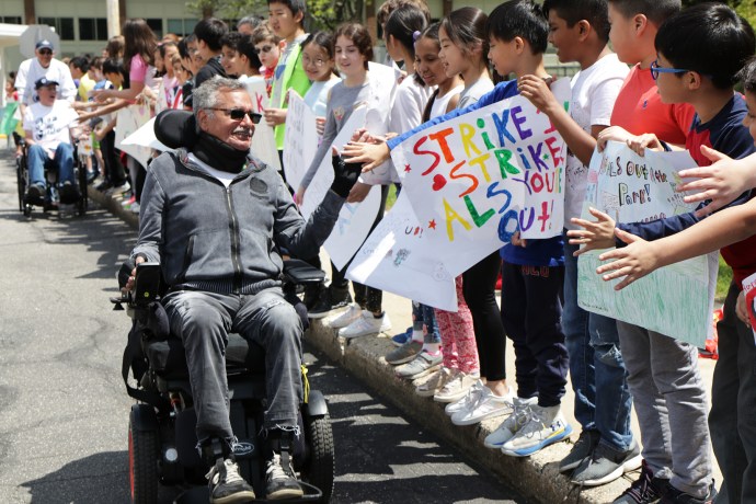 Ride for Life founder Christopher Pendergast is joined by Principal Dr. Michael Grimaldi, teacher Christopher Lynch, and fellow Ride for Life participants at the E.M. Baker School. (Photo courtesy of Great Neck Public Schools)