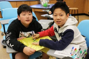 Seventh graders decorate superhero capes and masks with designs that feature messages of inspiration, hope, and courage. (Photo courtesy of Great Neck Public Schools)