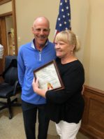 Janet Carman, a member of the village staff, holds her proclamation up with Mayor Adam Hoffman. (Photo by Billy Fitzpatrick)