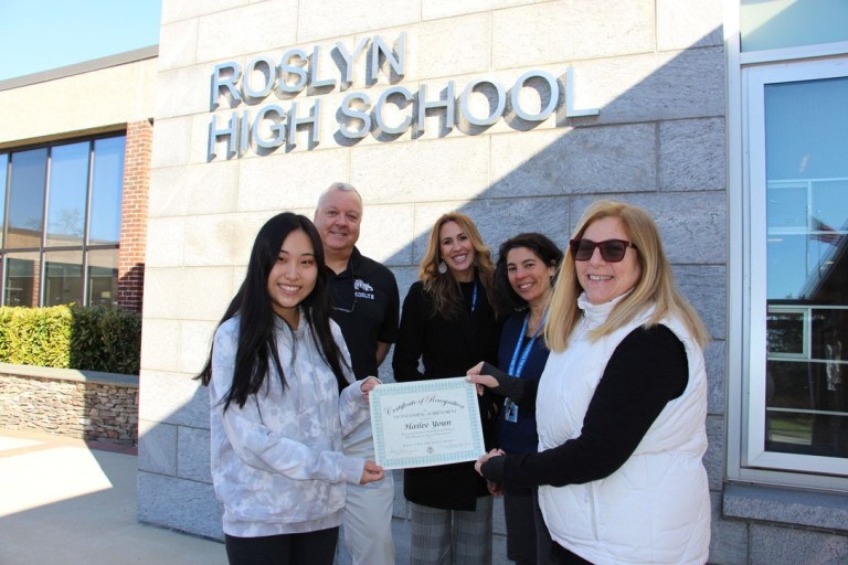 Roslyn BOE president bestows certificate or recognition to senior Hailee Youn