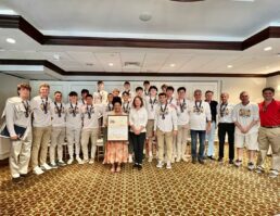 North Hempstead Town Supervisor Jennifer DeSena (center-right) and New York State assemblywoman Gina Sillitti (center-left) posing with the Manhasset boys varsity basketball team during a ceremony honoring their first state championship since 1986 at the Plandome Country Club.