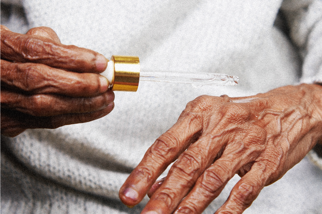 Senior applying CBD oil to hands