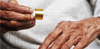 Senior applying CBD oil to hands